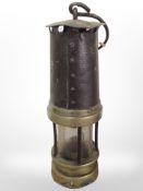 A 19th-century brass and steel miner's lamp.
