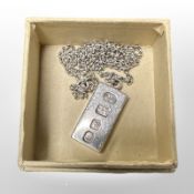 A silver ingot pendant on chain.
