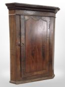 A George III oak corner cabinet,