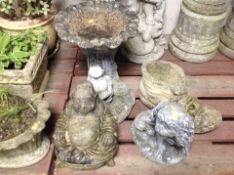 A concrete birdbath, height 47cm, and three further ornaments including Buddha,