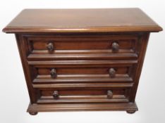 A reproduction three drawer chest on bun feet,