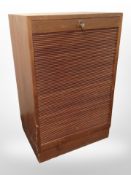 A Danish teak tambour front cabinet with key,