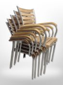 A set of five chrome-framed oak stacking patio chairs.