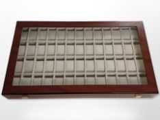 A contemporary lacquered watch display case with compartments for fifty two watches,