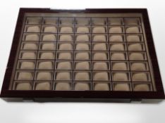 A contemporary lacquered watch display case with compartments for fifty six watches,