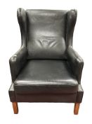 A Danish black leather wingback armchair, width 71cm.