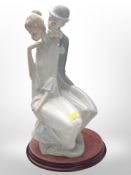 A large Nao figure group of a seated lady and gentleman, on plinth, overall 42cm high.