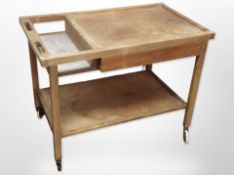 A 20th-century Danish teak two-tier serving trolley on castors, length 81cm.