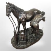 A resin figure of a farrier, together with a further figure of a jockey on horseback, tallest 26cm.