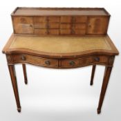 A reproduction mahogany lady's writing desk with tooled inset leather panel,