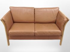 A late 20th century Danish stitched tan leather oak framed two seater settee,
