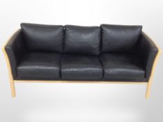 A late 20th century Danish stitched black leather beech framed three seater settee,