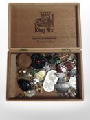 A cigar box containing various trinkets including a trench art double half penny fob on suspension