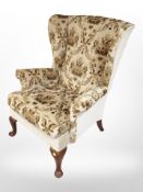 A reproduction wing back armchair,