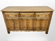 An Ercol 'Golden Dawn' triple-door sideboard fitted with three drawers,
