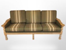A 20th century Danish blond oak framed three seater settee in striped upholstery,