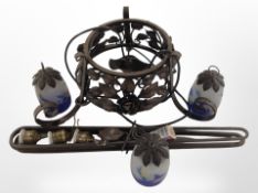 A wrought-metal pendant light fitting with three marbled glass shades.