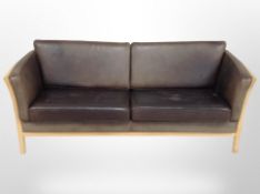 A late 20th century Danish beech framed three seater settee, upholstered in faded brown leather,