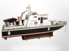 A scale model remote control boat marked 'Northern Guardian', on wooden stand, length 122cm.