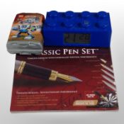 A LEGO clock, a LEGO Creator set, and a classic pen set sealed in cellophane.