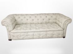 A Victorian style Chesterfield button back three seater settee, raised on bun feet,