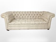 A Victorian style Chesterfield button back three seater settee, raised on bun feet,