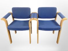 A pair of Danish Magnus Olesen laminated wood-framed office armchairs in blue fabric.