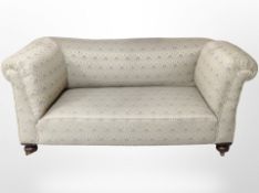 A Victorian style two seater drop-end settee, on bun feet,