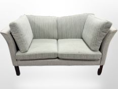 A Danish Hurup two-seater settee, upholstered in light green and white striped fabric,