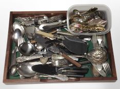 A teak tray containing assorted EPNS and stainless steel flat wares.