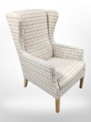A 20th century wing back armchair in checked fabric,