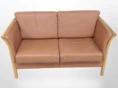 A late 20th century Danish stitched tan leather oak framed two seater settee,