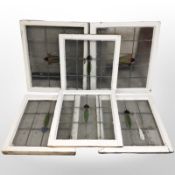 Six Art Nouveau stained leaded glass windows in distressed painted pine frames,