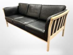A Danish beech-framed three-seater black leather settee, 195cm wide x 77cm deep x 70cm high.