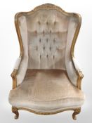 A 20th century continental carved beech framed wing back armchair,