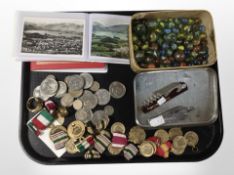 A quantity of vintage glass marbles, crowns, two albums of Lake District postcards, medals, etc.