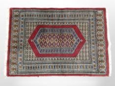 An Iranian rug on red ground, 94cm x 63cm.