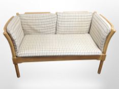 A Danish beech-framed two-seater settee in checkered oatmeal fabric,