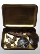 A Princess Mary brass Christmas 1914 tin containing enamelled badges, German cap badge, compass,