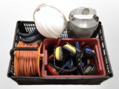 A group of tools and hardware, ear protectors, extension reel, hard hat, etc.