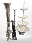 A group of decorative metal candlesticks, large trumpet vase, and a four-tier graduated stand,