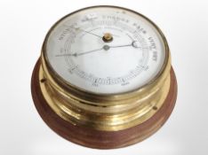 A circular brass barometer, diameter 20cm.