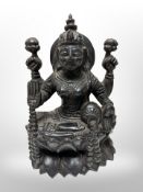 A carved hardwood Hindu figure of Lakshmi seated on lotus blossom, height 27cm.