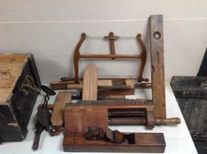 A vintage pine crate containing assorted joinery tools including vices, woodworking plane, level,