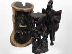 A carved wooden elephant, a further African carved figure group, and an imp face carved in wood,