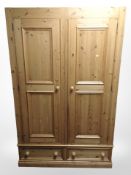 A contemporary pine double-door wardrobe, 120cm wide x 55cm deep x 193cm high (lacking cornice).