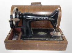 A Singer hand sewing machine in oak case.