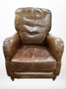 A contemporary chestnut-brown studded leather manual reclining armchair,