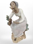 Two Lladró bisque figures of ladies beside tree stumps, tallest 35cm.