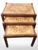 A 20th-century nest of three teak tile-topped tables, width 60cm.